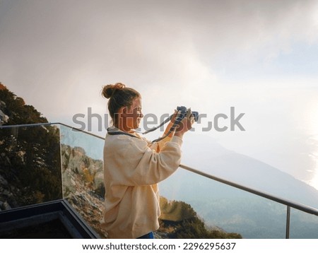 woman enjoys the view from the viewpont over Oludeniz, Turkey. Sunset, clouds, paragliders. Mount Babadag