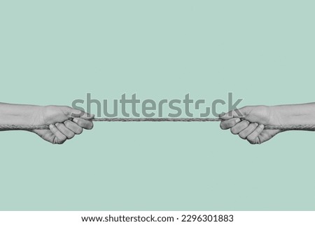 two men pulling each of the opposite ends of a rope in black and white, on a pale green background Royalty-Free Stock Photo #2296301883