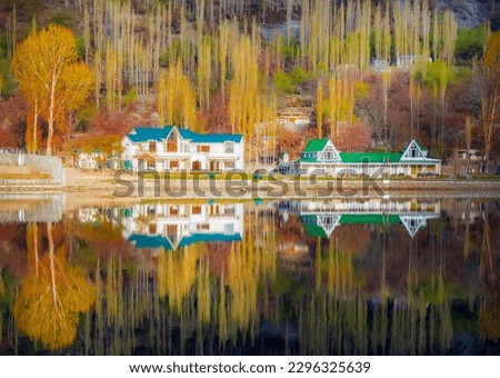 landscape of autumn trees green huts colorful trees and , reflection of autumn trees and green huts in the calm water of lake 