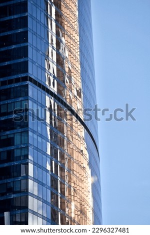 Futuristic part of skyscrapers design on clear blue sky background. Abstract facade design. Glass and metal in modern city architecture. Modern buildings exterior. Construction industry. Abstraction.