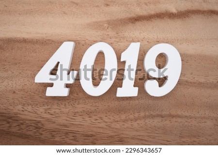 White number 4019 on a brown and light brown wooden background.