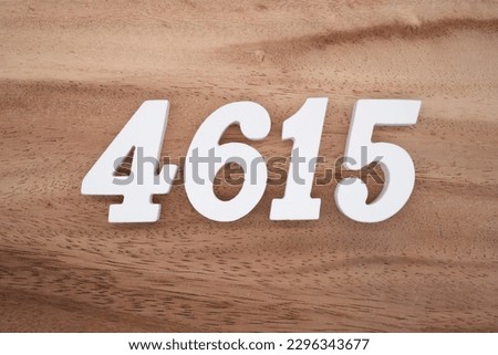 White number 4615 on a brown and light brown wooden background.