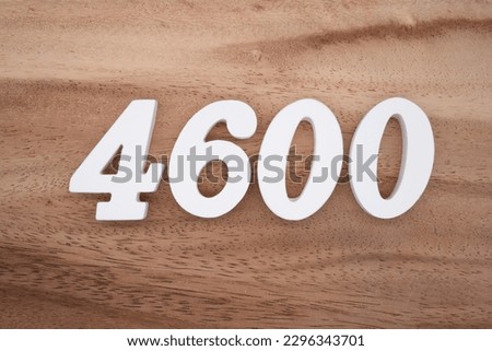 White number 4600 on a brown and light brown wooden background.