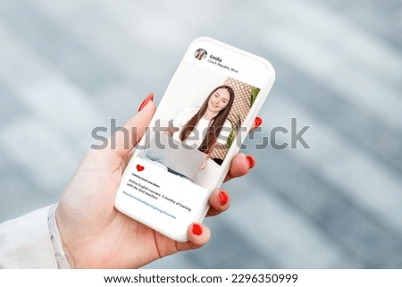 Woman looking at beautiful model's photo on mobile phone