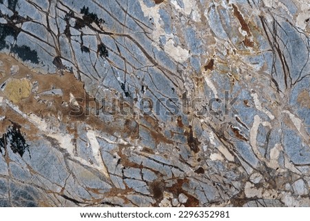 Close-up beautiful abstract beige, blue and red marble background with dark spots. Template for design.