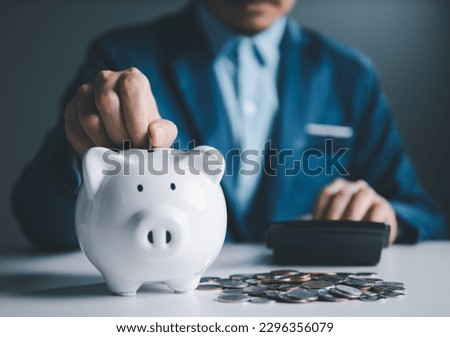 Unlocking the Power of Savings: Innovative Approaches to Managing Money, Currency, Cash, and Investment for Long-Term Wealth and Financial Security. Businessman put coins into white piggy bank.