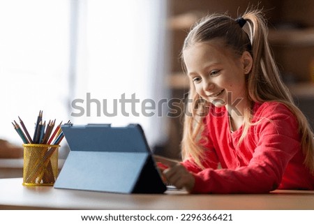 Modern Technologies. Cute Little Girl Using Digital Tablet At Home, Smiling Preteen Female Child Study Online On Tab Computer, Enjoying Remote Education And Distance Learning, Copy Space