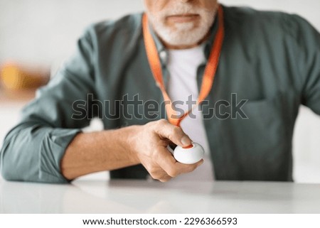 Unrecognizable Senior Man Pressing Emergency Call Button For Quick Help, Closeup Shot Of Elderly Gentleman Giving Sos Alarm Panic Call While Sitting At Desk At Home, Selective Focus Royalty-Free Stock Photo #2296366593