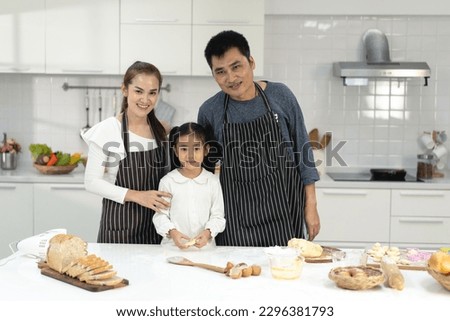 Happy asia family with daughter making dough preparing baking cookies, Daughter help parent preparing the bake Family concept