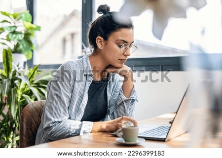 Shot of beautiful attractive entrepreneur woman working with laptop while drinking coffee in the living room at home. Royalty-Free Stock Photo #2296399183