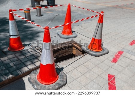 Street sinkhole repair . Red repair cones fencing the street 