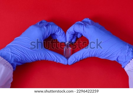 Blue latex gloves for medical protection in heart symbol Concept to support doctors and nurses. Covid-19 coronavirus. Red background.