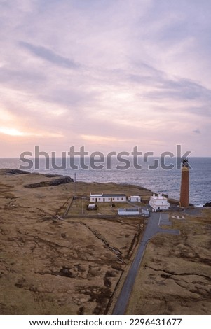 Aerial view of sunset and lilac sky over Butt of Lewis Lighthouse in the Outer Hebrides of Scotland.