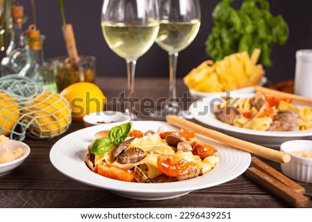 Traditional italian seafood pasta with clams vongole. Two white wine glasses on the background. Romantic or family dinner concept. Royalty-Free Stock Photo #2296439251