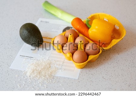 Recipe printed on a sheet of paper with ingredients on a white stone kitchen surface