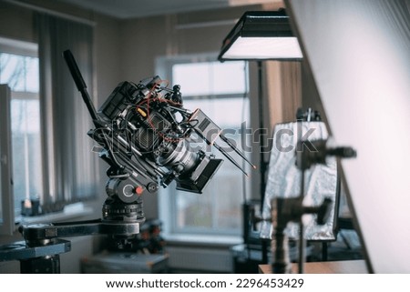 Professional cinema and video camera on the set. Shooting shift, lighting fixtures, shooting equipment and the team. Technique of modern filming and advertising. Royalty-Free Stock Photo #2296453429
