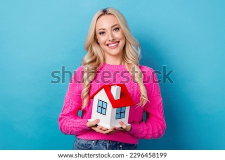 Photo of optimistic nice good mood person with curly hairdo dressed knit sweater hold small house isolated on blue color background