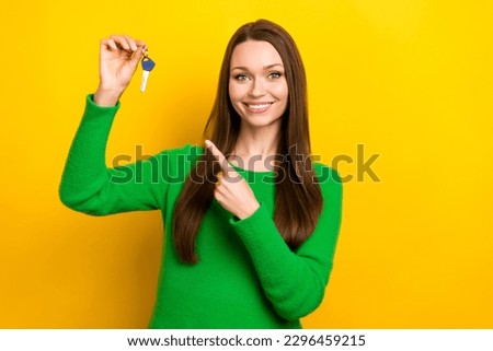 Photo of charming cheerful person indicate finger hand hold house key isolated on yellow color background
