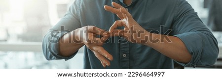Close up of businessman using sign language while talking with client sitting in office
