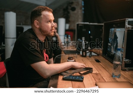 Director at work on the set. The director works with a group or with a playback while filming a movie, advertising, or a TV series. Shooting shift, equipment and group. Modern photography technique.