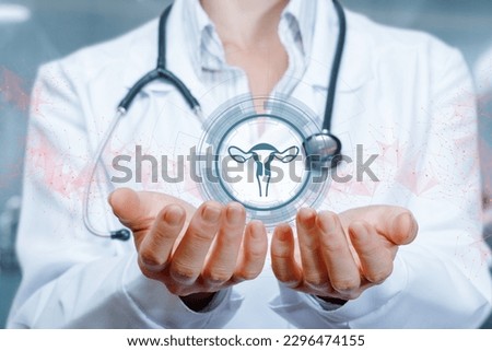 The doctor supports the uterus icon in hand on blurred background.