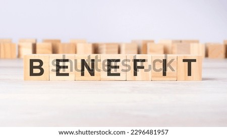 word BENEFIT inscribed on wooden cubes lying on a light table. business concept.