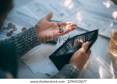 Close-up of men's hands with an empty wallet, a bunch of utility bills, a calculator and coins. The concept of increasing the cost of heating, gas, electricity and utility services Royalty-Free Stock Photo #2296510677