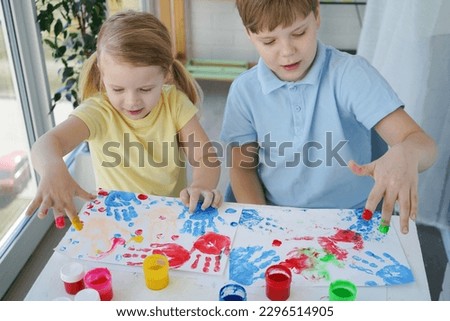 Kids have fun and create picture. Palms of different colors. Sensory development and experiences, themed activities with children, fine motor skills development.