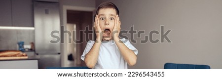 Funny scared small boy expressing shocked emotions about lessons. Scary homework. Royalty-Free Stock Photo #2296543455