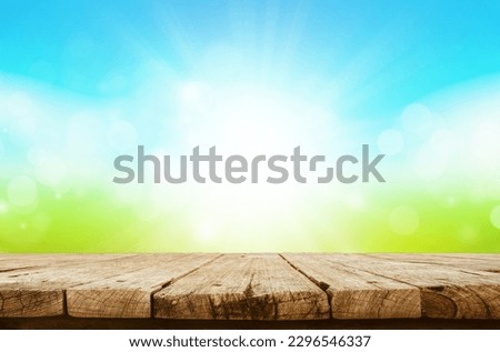 Empty wooden table are placed outdoors on spring blue sunny sky background with sun shine and bokeh blurry. Counter display concept