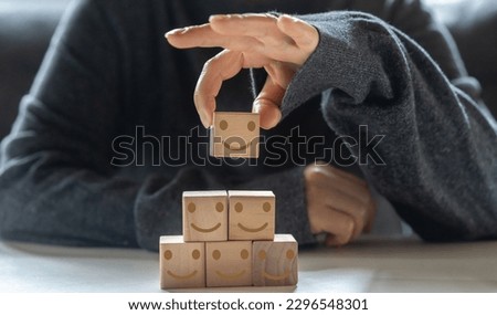 Hand holding wood block symbol face smile, happy, relax,  satisfaction survey, customer services, positive, good, wellness, health child, hospital, world mental health day concept Royalty-Free Stock Photo #2296548301