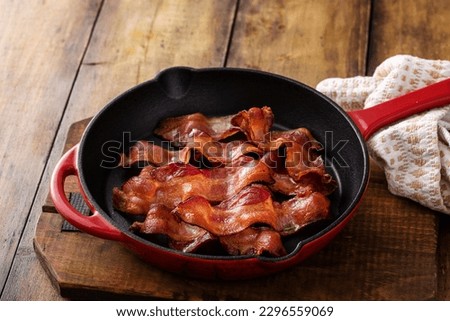Cooked bacon in a cast iron pan, ready to eat breakfast staple Royalty-Free Stock Photo #2296559069