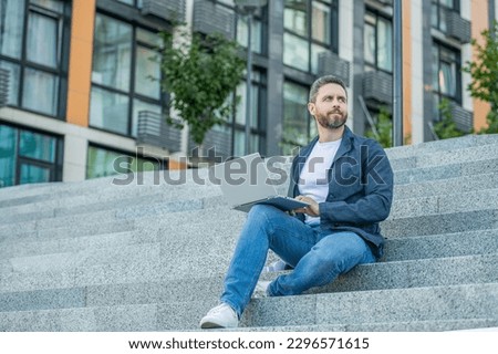 freelancer man with pc outside on stairs. photo of freelancer man with computer.