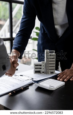 Real estate agents and clients shake hands after completing a contract after dealing with home insurance and home investment loans, investing in real estate.  Leases, Successful Agreements