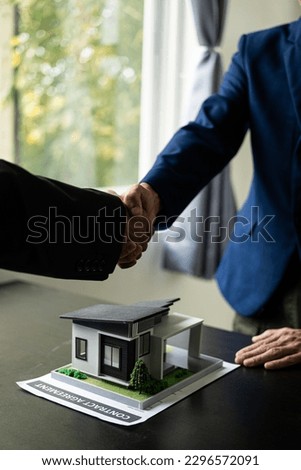 Real estate agents and clients shake hands after completing a contract after dealing with home insurance and home investment loans, investing in real estate.  Leases, Successful Agreements