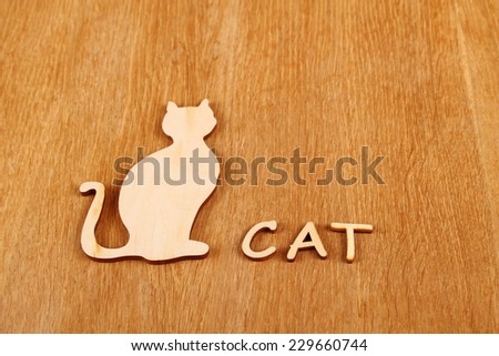 Wooden silhouette of a cat on a wooden surface. Background
