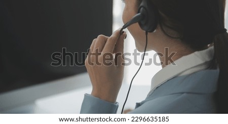 Young friendly operator woman agent with headsets working in a call centre. Royalty-Free Stock Photo #2296635185