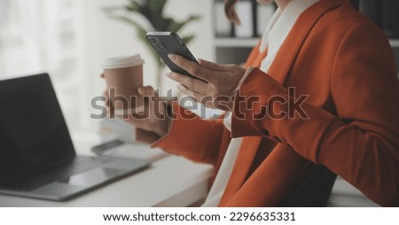Attractive smiling young asian business woman work at home office, Asian woman working on laptop computer holding tablet.