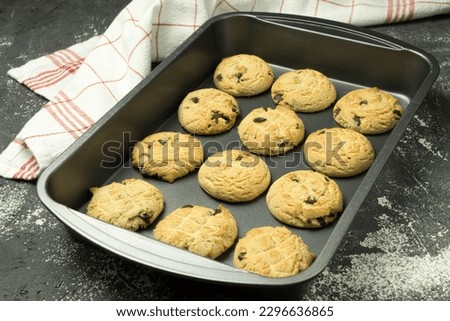 Cookies with chocolate on a baking sheet. Chocolate chip cookies on a baking sheet, just out of the oven, with crumbs. Space for text