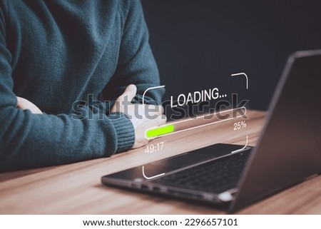 Young man using a laptop computer for download and update software and waiting to loading digital file data form website, very slow internet form wifi. Concept of waiting for load of loading symbol.
