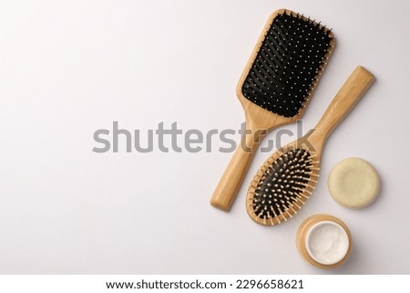 Wooden hairbrushes and cosmetic products on white background, flat lay. Space for text Royalty-Free Stock Photo #2296658621