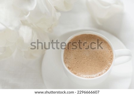 Cozy morning coffee cup with white tulip flowers from above, breakfast on Mothers day or Womens day. Top view with copy space Floral composition Romantic background