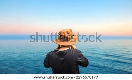 The Old man at the beach taking picture in early morning of sunrise