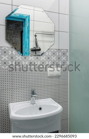 Bathroom with white tiles, mirror and washbasin.