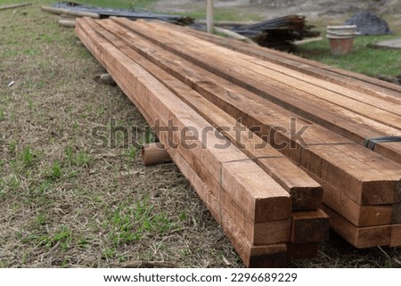 Wood timber construction material. Closeup big wooden boards. Stacked wooden beams of square section for house construction