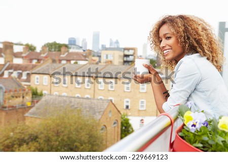 Woman Relaxing Outdoors On Rooftop Garden