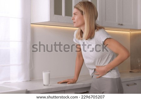 Woman suffering from lactose intolerance in kitchen Royalty-Free Stock Photo #2296705207