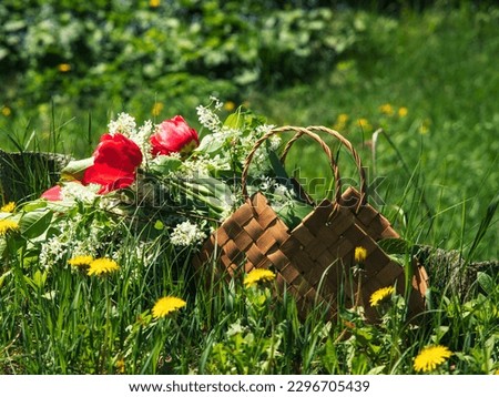 Basket with flowers on the spring lawn