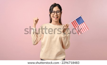 Confident Asian girl showing a USA flag on pink isolated background, education concept. study abroad concept. Royalty-Free Stock Photo #2296718483
