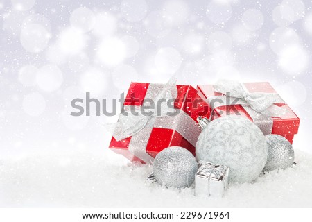 Christmas baubles and red gift boxes over snow bokeh background with copy space Royalty-Free Stock Photo #229671964